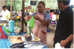 Federico Morta, a beneficiary of Pantawid Pamilya and Sustainable Livelihood Program sells fresh fish in the local market in Jabonga, Agusan del Norte