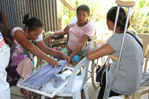 Participants actively show their prowess in making rug during the Skills Training for Women with Disability.