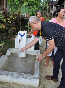 Gov. Pimentel washes his hands with the water from the tap stand.