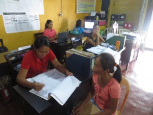 Lucita Laurente (in red shirt) entertains a Pantawid Pamilya beneficiary