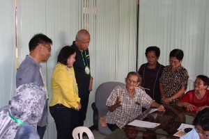 Regional Director Minda B. Brigoli (in yellow long sleeve) and SurSur Governor Johnny T. Pimentel (in black polo shirt) joyfully converse with  100 - year old Mr. Vidal M. Bagnod, former mayor and vice mayor of Cortes, SurSur. Dir. Brigoli handed -  in today a cash gift  to lolo Vidal as an incentive for reaching a hundred - year old.