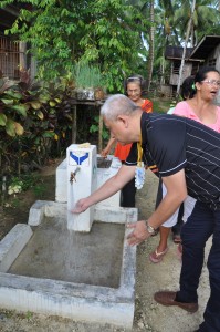Gov Pimentel washes his hands with the flowing water of   the sustained community sub-project in Tagbina, Surigao del Sur